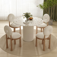Ensemble de table à manger circulaire en terrazzo de luxe avec chaise à piétement cannelé et dossier torique, design moderne pour hôtel et villa