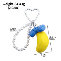 Vente en gros : Breloque de sac banane Kawaii tendance, porte-clés avec nœud et chaîne de perles et fermoir cœur, cadeau adorable pour filles