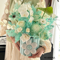 Arrangement floral tridimensionnel mignon de style coréen, avec un joli seau à collation et des petites boîtes en papier rondes, pour une composition florale artistique et une ambiance douillette