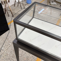 Vitrine à bijoux autoportante en verre avec cadre noir, pieds hauts et éclairage LED pour les bijouteries professionnelles