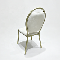 Chaise d'événement empilable en métal doré avec poignée intégrée dans le dossier et coussin blanc pour hôtels et salles de banquet
