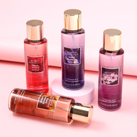 Brume Corporelle Parfumée pour Femme – Flacon Cylindrique Violet avec Capuchon Doré, Motif Floral Étoile de Mer et Ruban – Collection Été Briseée Longue Durée