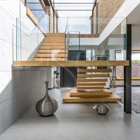 Escalier flottant en bois massif avec éclairage LED, poutres en acier invisibles et garde-corps en verre trempé