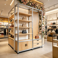Système d'affichage modulaire en métal argenté avec étagères en bois, panneaux arrière éclairés et zone perforée pour magasin de détail
