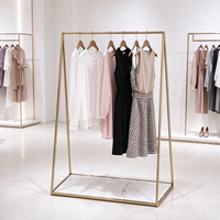 Portant à vêtements pour boutique, structure tubulaire dorée, table de présentation en marbre avec plateau en verre, rail de suspension, CE ETL, vente en gros et au détail