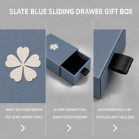 Boîte cadeau à tiroir coulissant bleu ardoise avec emblème de fleur blanche et intérieur en velours noir, impression personnalisée pour l'emballage de bijoux