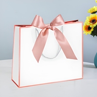 Sacs cadeaux en carton recyclable de luxe avec nœud, poignées longues, impression de logo personnalisée pour l'emballage de vêtements, de cosmétiques et d'artisanat