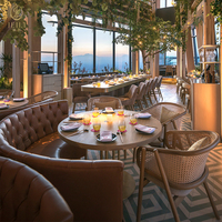Ensemble de mobilier commercial JEILI pour restaurant : banquette en cuir marron, table ronde et chaises en rotin pour projets hôteliers et d'accueil.