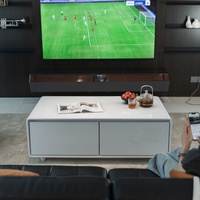 Appareils électroménagers modernes pour salon : Réfrigérateur intelligent, table basse avec écran tactile et recharge sans fil pour le sport, les films et les jeux