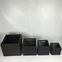 Sphères de topiaires artificielles en buis, style minimaliste moderne, dans des pots carrés noirs pour la décoration intérieure.