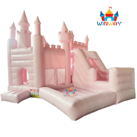Château gonflable rose sur le thème des princesses avec piscine à balles, aire de jeux extérieure pour enfants.