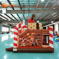 Château gonflable de Noël Ceyu en forme de maison de pain d'épices avec toit 3D, mascotte, piliers en forme de canne à sucre et entrée en forme de gable enneigé pour location événementielle
