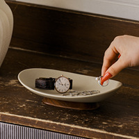 Plat en grès de forme bateau à rebord surélevé, sur support en bois d'acacia tourné, corps moucheté de sable, disponible en petites, moyennes et grandes tailles, idéal comme plateau de service pour canapé, sushi, ou plateau de présentation pour bijoux et articles de toilette.