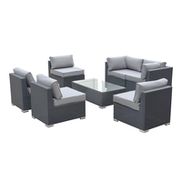 Ensemble table et canapé en rotin tressé avec structure en aluminium de style moderne, finition thermolaquée, pour hôtels et cours.