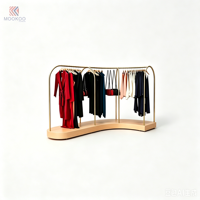 Porte-vêtements en métal doré incurvé avec base en bois clair, support de présentation pour vêtements, présentoir pour boutique de vêtements, pour magasin de vente au détail