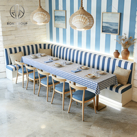 Ensemble de mobilier pour café, restaurant, comprenant chaises demi-circulaires courbes, table et banquette.