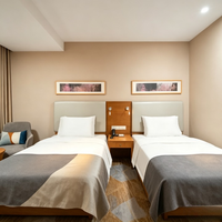 Ensemble de mobilier moderne pour chambre double d'hôtel : lit avec tête de lit capitonnée en placage de bois, chevet et fauteuil de détente