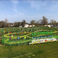Manège pliable géant Caterpillar vert sur remorque, équipement d'amusement portable, idéal pour les fêtes foraines nomades.
