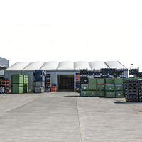 Tente de stockage industrielle à toit courbé, parois en panneaux sandwich ondulés, porte large pour véhicules, pour le transit de marchandises sur palettes en usine et en entrepôt