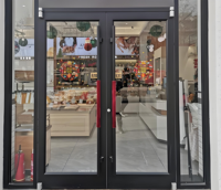 Porte d'entrée de magasin Prix d'usine Portes commerciales Système coulissant Cadre en aluminium Porte de magasin en verre trempé
