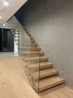 Escalier flottant intérieur avec poutre en acier dissimulée et garde-corps en verre pour projet de villa