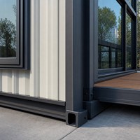Maison en structure acier portable avec intérieur lumineux, fenêtres en verre et terrasse