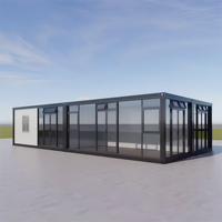 Cette petite maison conteneur combine un mur-rideau en verre noir et blanc avec une isolation intelligente et une terrasse sur le toit.