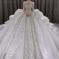 Robe de mariée de luxe 2026, col en V, manches longues, traîne chapelle, ornée de cristaux, richement perlée, coupe trapèze, jupe volumineuse à étages spectaculaire, style robe royale