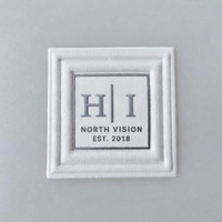 Étiquettes personnalisées en coton TPU avec logo 3D en relief, toucher doux, pour vêtements, streetwear et accessoires.