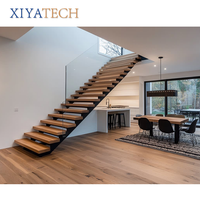 Escalier flottant contemporain XIYATECH avec marches en bois massif éclairées par LED, garde-corps en verre et limon en acier invisible
