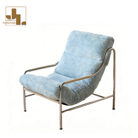 Fauteuil de salon confortable en tissu avec structure métallique, style moderne, pour chambre d'hôtel, villa ou salon.