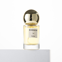 Flacon de parfum en verre transparent cylindrique de 15 ml, format voyage, avec vaporisateur et capuchon rond, pour parfum de luxe.