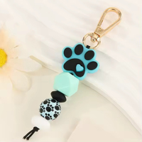 Porte-clés en silicone patte de chat avec perles, pompon moelleux et perles en bois, fait main, léger, avec technique de tissage