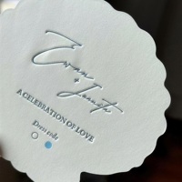 Invitation de mariage haut de gamme imprimée en offset avec motif coquillage et branche en relief sur papier offset