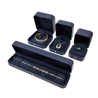 Boîte à bijoux en cuir PU grainé bleu marine avec fermeture à bouton doré pour l'affichage de bracelets haut de gamme et la mise en valeur professionnelle de la marque