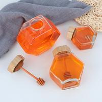 Tarro de miel al por mayor de cristal con forma hexagonal, recipiente para miel con cucharón de madera y tapa de corcho, almacenamiento de miel y jarabe en forma de colmena