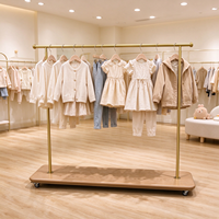 Étagère de présentation de vêtements pour enfants dorée avec roulettes, personnalisée pour les magasins de vêtements pour enfants, présentoir de vêtements sur mesure