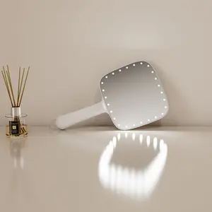 Pasokan pabrik putih Label pribadi rias wajah massal cermin rias bercahaya portabel dengan lampu Led genggam tangan memegang cermin perjalanan