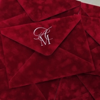 Ensemble d'enveloppes d'invitation de mariage en velours camel de luxe, avec motif botanique d'orchidée en relief et impression personnalisée en or.