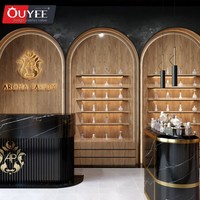 Comptoir présentoir de parfums en marbre au design d'intérieur Parfumerie unique Vitrine murale arquée en placage de bois pour parfumerie avec lumière LED