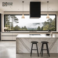 Meubles de cuisine modernes et minimalistes couleur crème avec fenêtre panoramique, îlot double cascade en marbre Statuario, menuiserie de penthouse