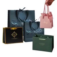 Design personalizzato manico a nastro gioielli di lusso neri abbigliamento regalo cosmetico Shopping Packaging 250 gsm sacchetto di carta patinata per vestiti