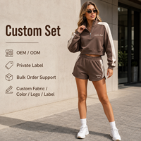 Conjunto de dos piezas al por mayor para mujer: Sudadera corta de algodón polar color moca con cremallera de cuarto y pantalones cortos casuales con paneles en contraste color marfil.