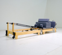 Appareil de Pilates pliable en chêne pour la vente au détail, incluant une boîte d'assise et un système de fixation, conçu pour un entraînement complet du corps.