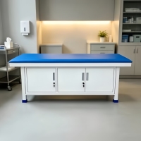 Table de diagnostic clinique équipée de trois unités de rangement pour accessoires médicaux, conçue pour les tâches d'examen hospitalier quotidiennes