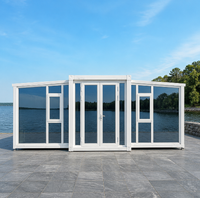 Maison conteneur pliable extensible blanche avec panneaux en verre et portes doubles pour le glamping en bord de lac, bureau de chantier