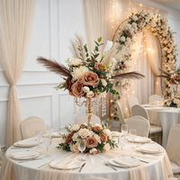 Centro de mesa vintage con rosas marrones y hierba de pampa para decoración de banquetes de boda.