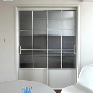 Porte coulissante à 4 panneaux en alliage d'aluminium avec grille cintrée, cadre fin et verre cannelé pour cloison intérieure d'hôtel boutique moderne - Product Image 1