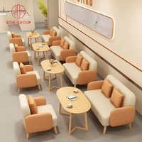 Ensemble de mobilier de restaurant commercial : Canapés deux places beige et vert, table basse ovale en bois moderne et durable avec pieds géométriques