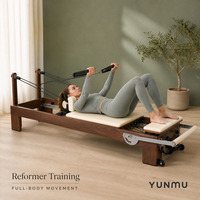 Machine de Pilates Reformer en bois de noyer noir pour studio commercial, avec barre de repose-pieds réglable couleur personnalisée, pour usage en salle de sport et à domicile